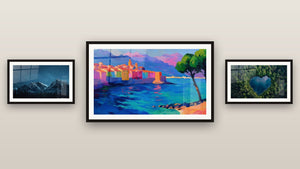 Pared de galería con tres cuadros enmarcados: Pueblo costero mediterráneo, Montaña nevada y Lago N°1