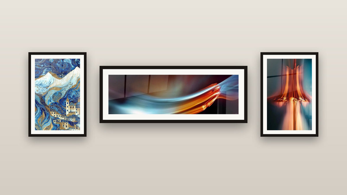 Pared de galería con tres cuadros enmarcados: Pueblo de Montaña, Flujo luminoso abstracto y Cascada de luz