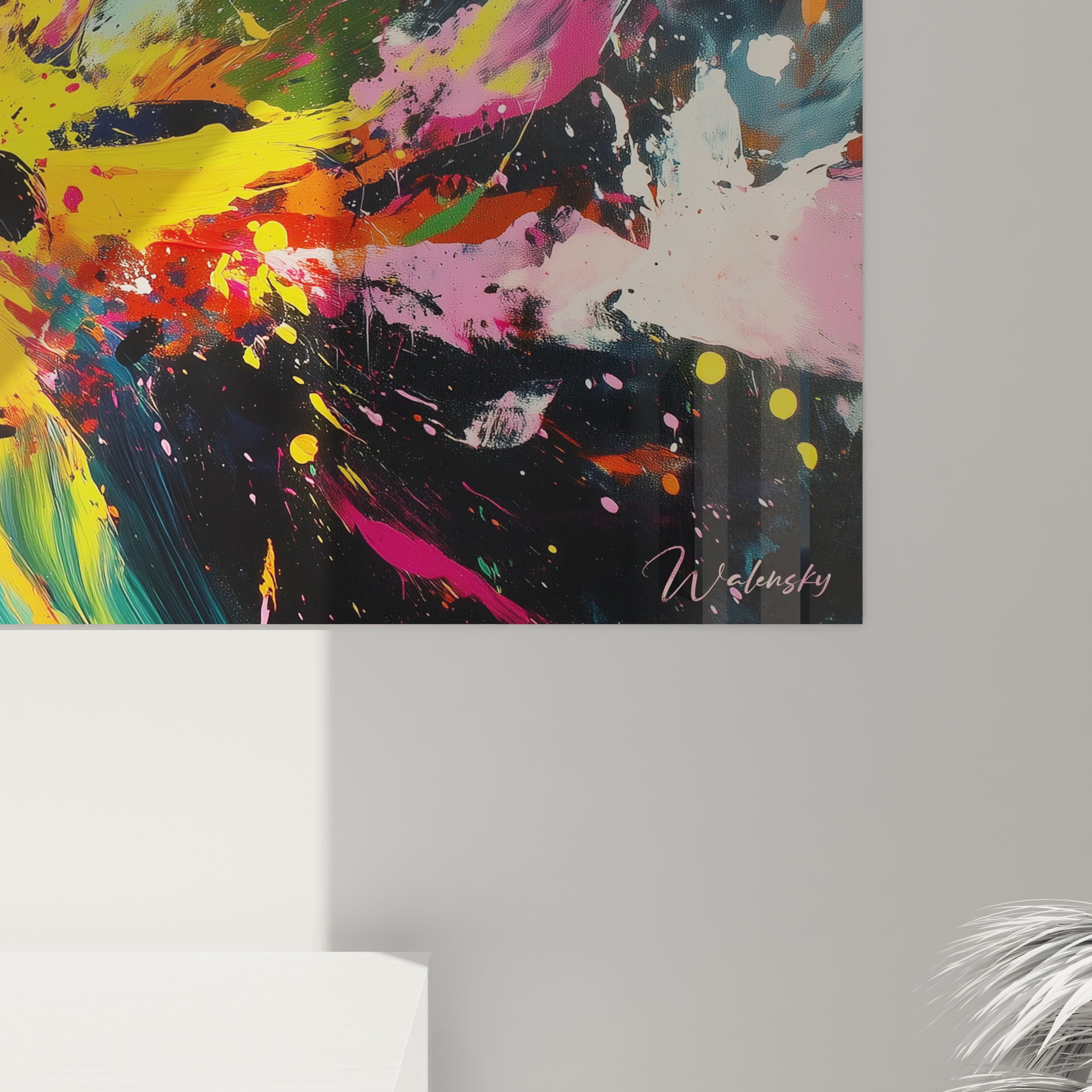 Un tableau graffiti expressif montrant une explosion de pigments colorés sur format panoramique noir, avec des éclaboussures dynamiques en tons de rose, jaune, turquoise et blanc qui semblent propulsées du centre vers les bords, formant des motifs radiaux aux textures variées et aux contrastes saisissants.
