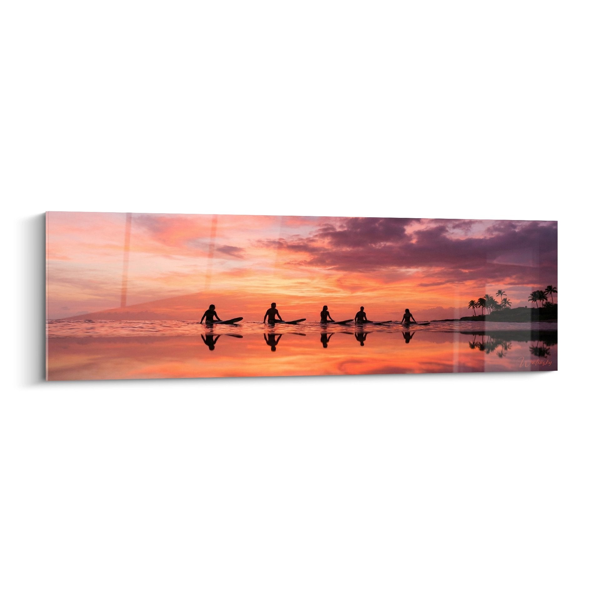 Tableau panoramique montrant cinq surfeurs en silhouette au crépuscule avec reflets dorés sur l'eau calme