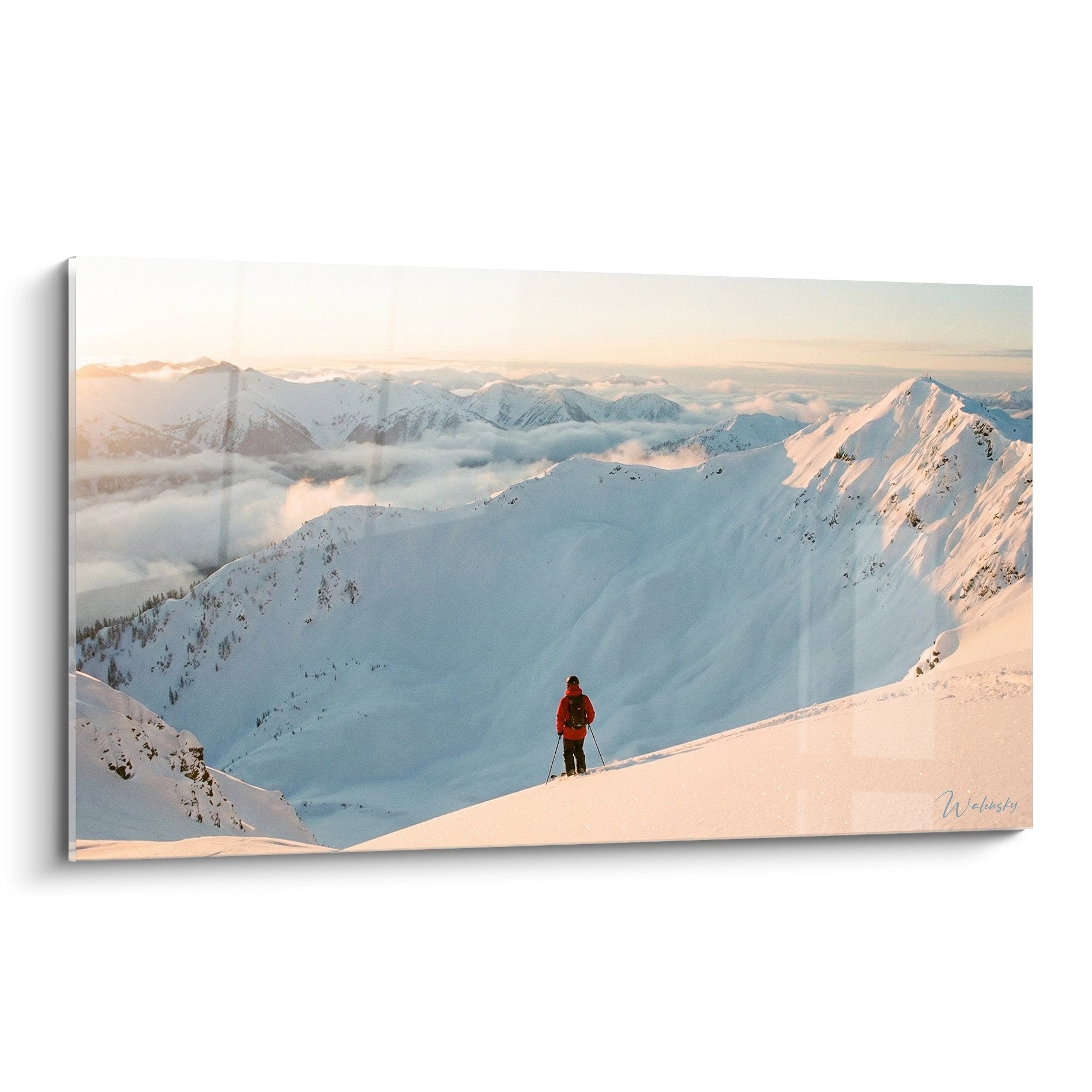 Tableau skieur rouge contemplant panorama montagneux enneigé au coucher du soleil, sommets alpins dorés