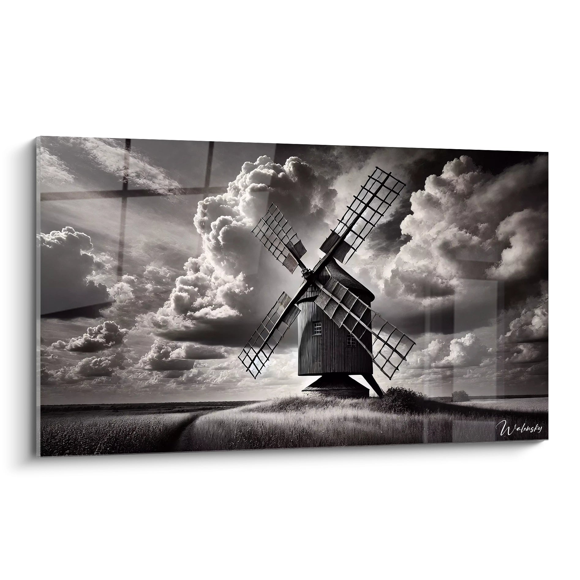 Tableau noir et blanc representant un moulin ancien sous un ciel tourmente vu de biais dans des nuances dramatiques de gris pour un effet intemporel et poetique.
