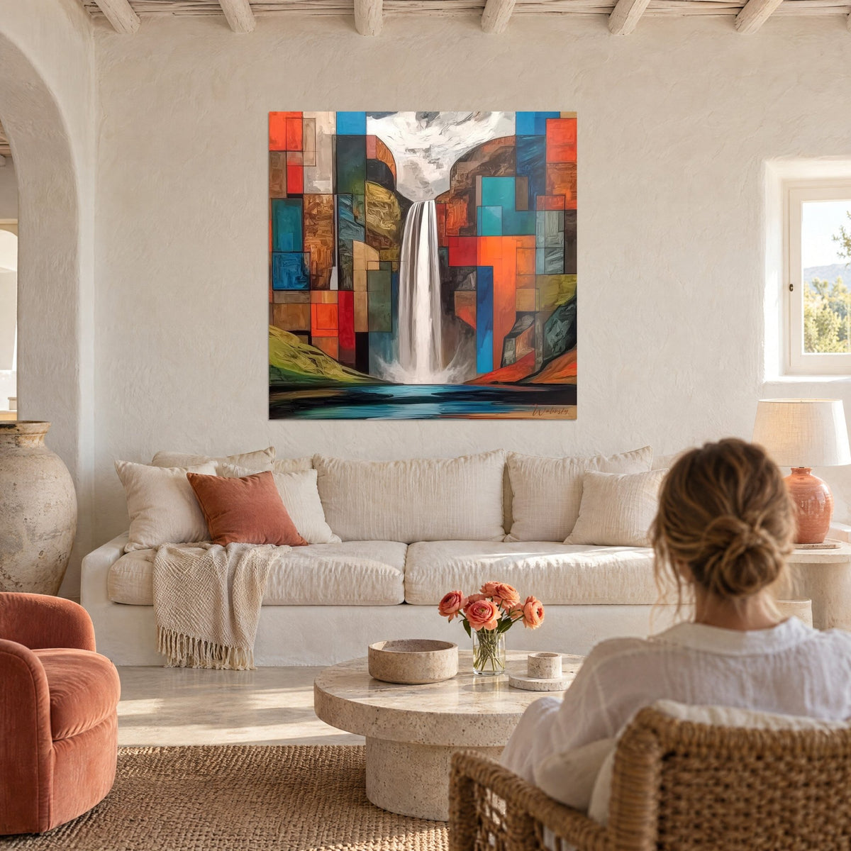 Gemälde mit weißem Wasserfall zwischen orangefarbenen und türkisfarbenen Blöcken, Frau von hinten, über einem Sofa in einem hellen Wohnzimmer