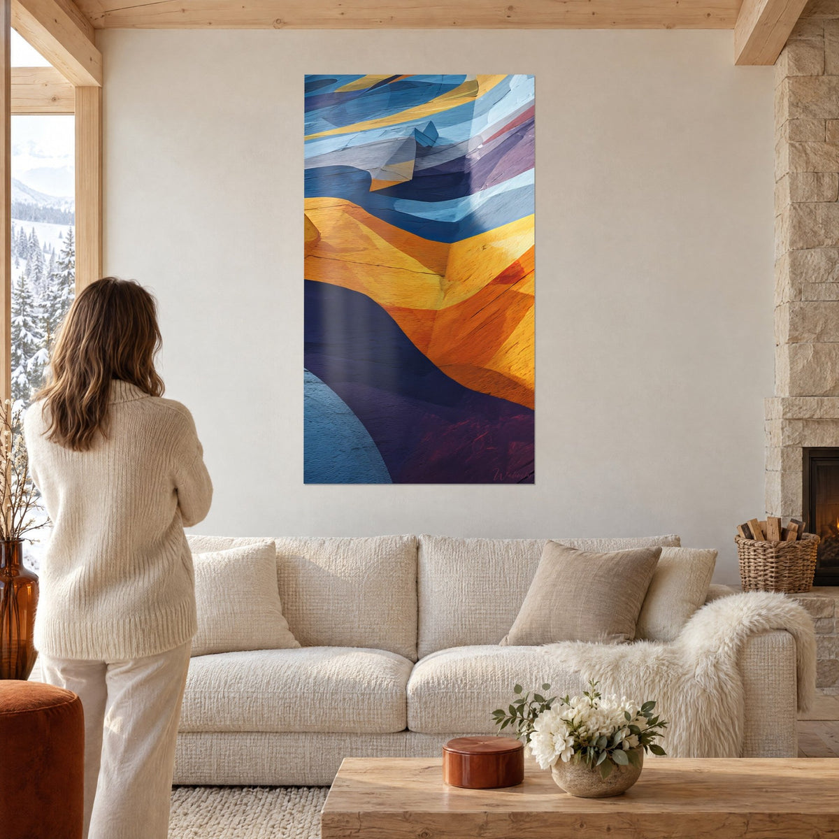 Tableau strates rocheuses ondulantes jaune safran et bleu nuit, femme de dos, au-dessus d'un canapé dans un salon lumineux