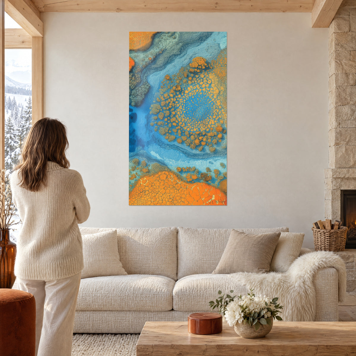 Gemälde Korallenatoll aus der Vogelperspektive, orangefarbenes Riff und türkisblaues Lagunenwasser, Frau von hinten, über einem Sofa in einem hellen Wohnzimmer