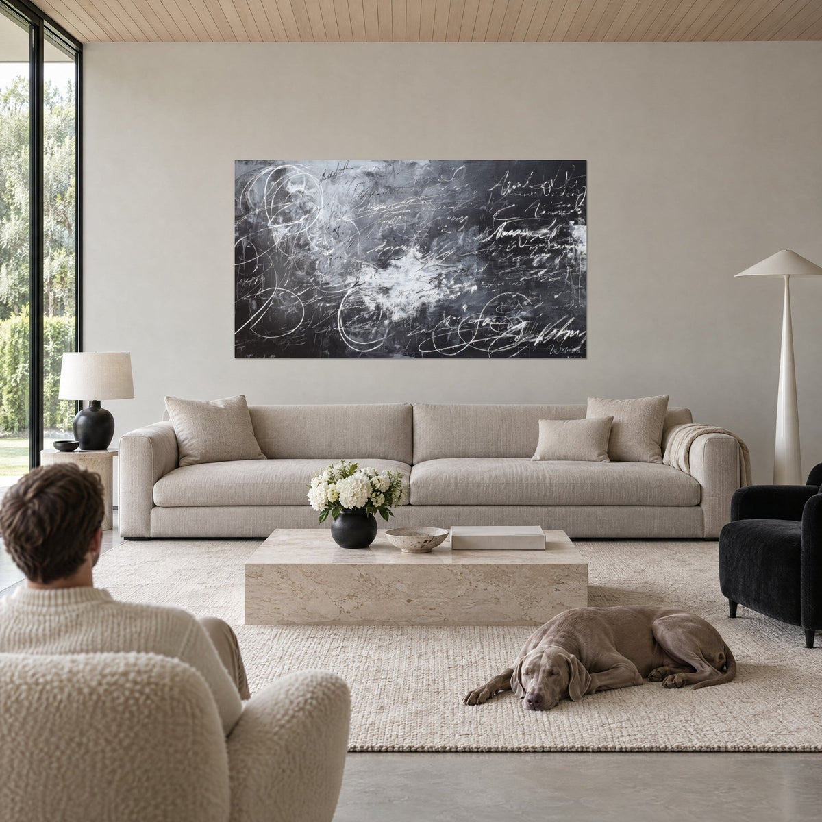 Wall art abstract calligraphy in white lines on black and grey background, chalk loops above a sofa in a bright living room