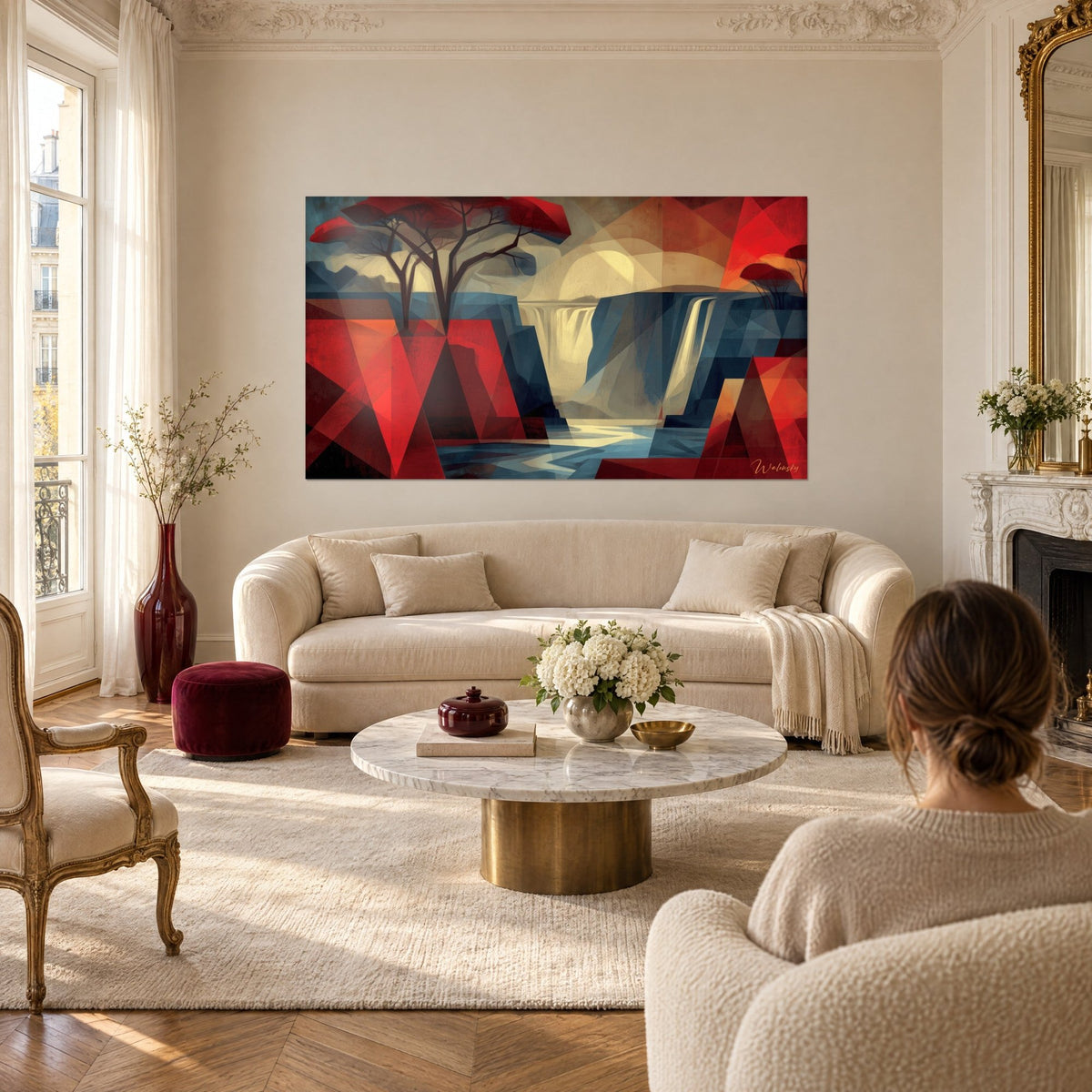 Tableau chute d'eau stylisée en facettes rouge vif et bleu ardoise, arbre noir ramifié, au-dessus d'un canapé dans un salon lumineux