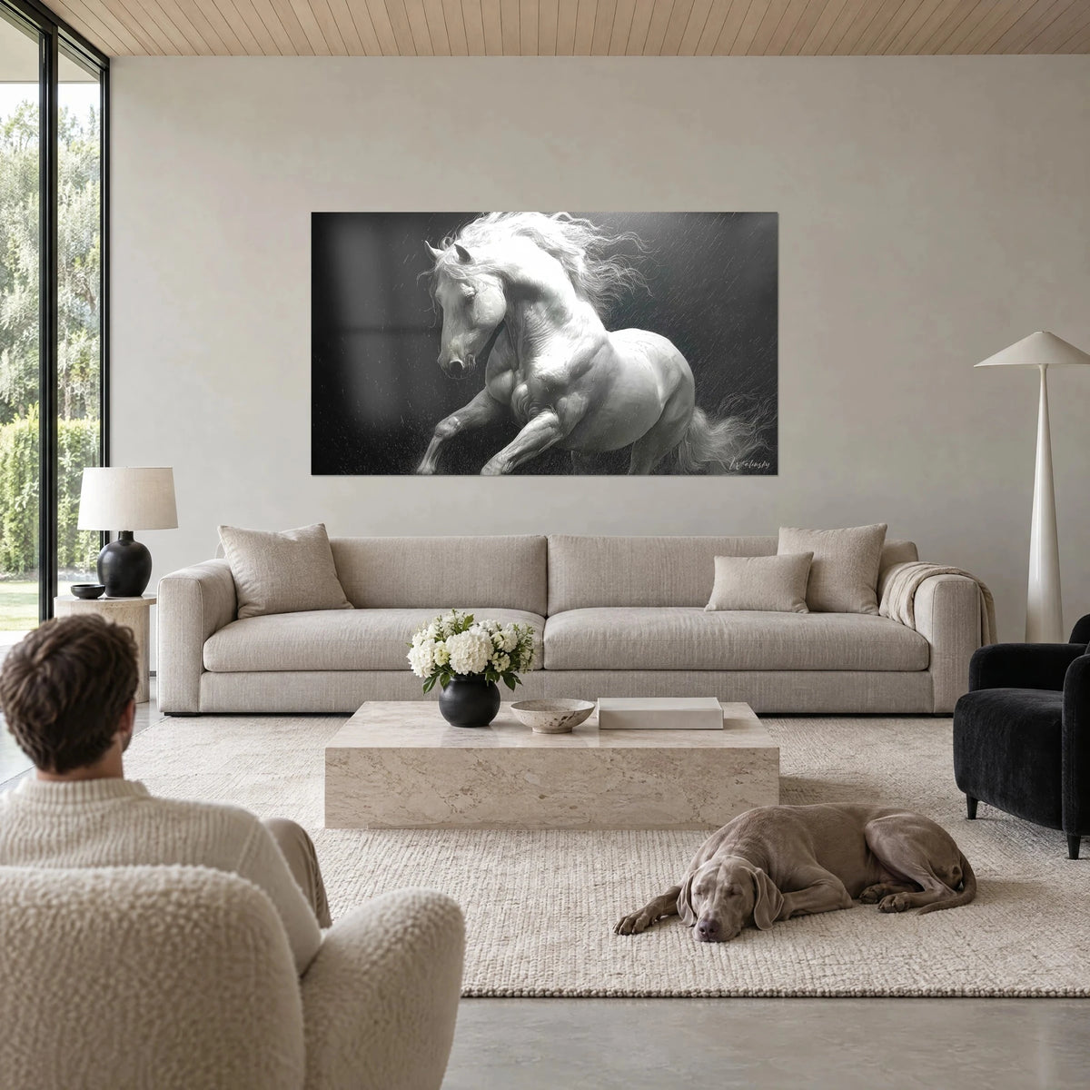 Gemälde weißer Hengst, sich aufbäumend im Regen, silbermähnig auf schwarzem Grund, Mann von hinten, liegender Weimaraner, über dem Sofa in einem hellen Wohnzimmer