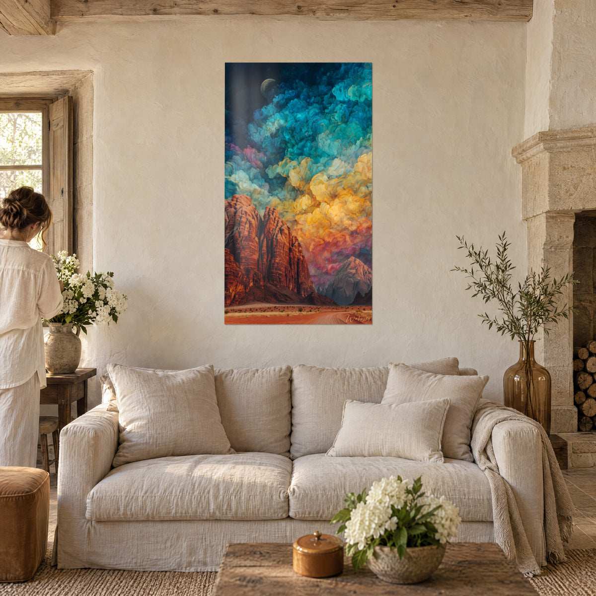 Gemälde mit roten Klippen unter türkisfarbenen und goldenen Wolken, Mondsichel, zwei Personen von hinten, über einem Sofa in einem hellen Wohnzimmer