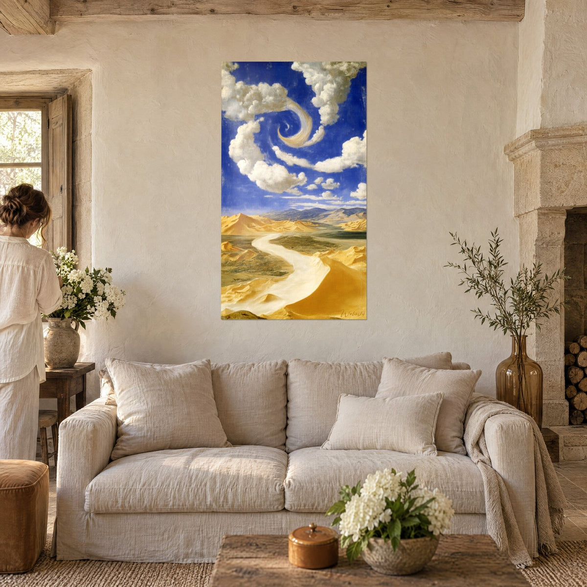 Gemälde goldene Dünen unter einem kobaltblauen Himmel, spiralförmige Wolken, klarer Fluss, eine Frau von hinten über einem Sofa in einem hellen Wohnzimmer