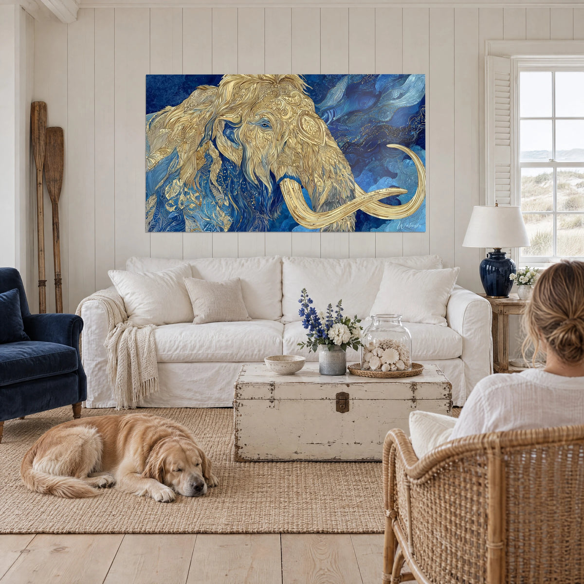 Gemälde Wollmammut mit goldenem Fell auf nachtblauem Hintergrund, über einem Sofa in einem hellen Wohnzimmer