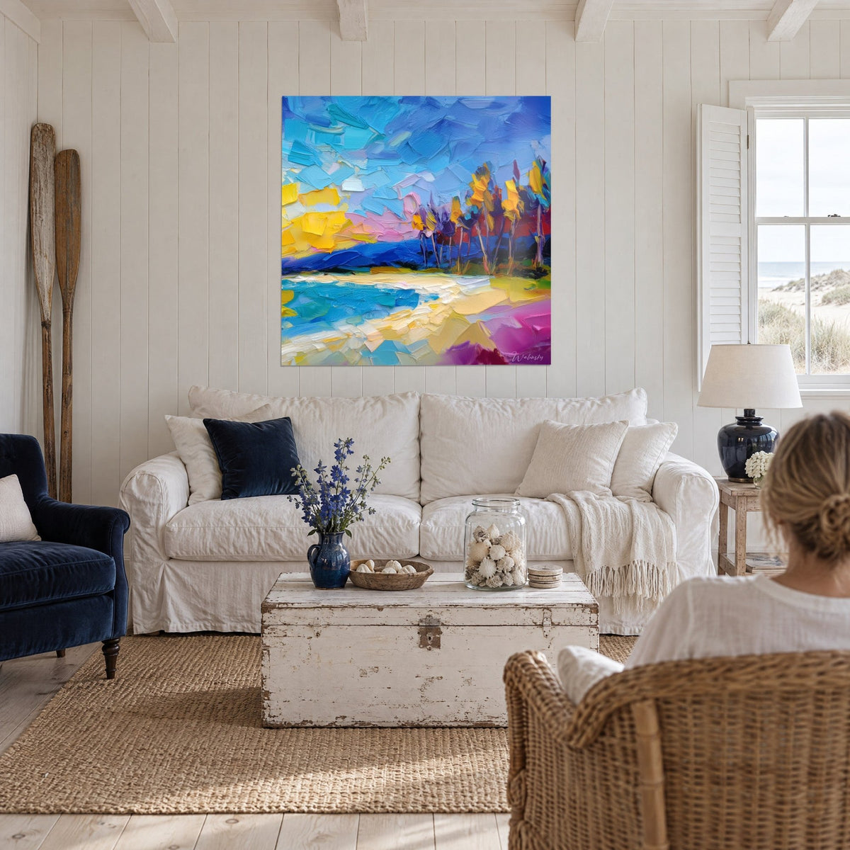 Gemälde tropischer Strand mit blauen und gelben Spachtelstrichen, violetten Palmen, über einem Sofa in einem hellen Wohnzimmer