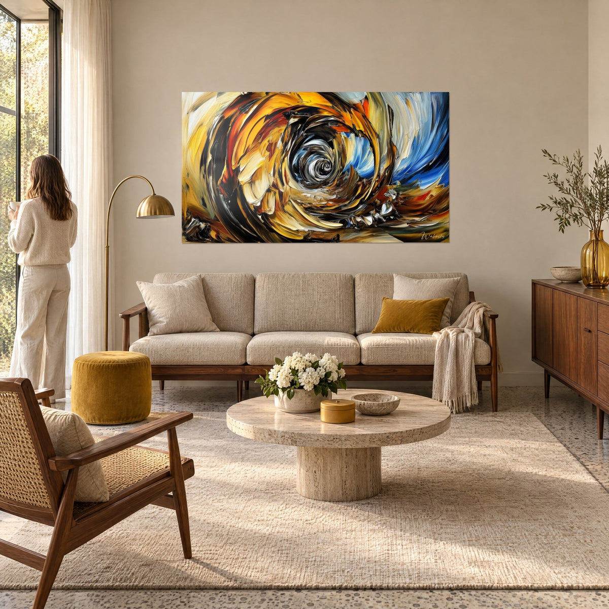 Tableau tourbillon ocre et bleu cobalt, spirale d'empâtements noirs et blancs, une femme de dos, au-dessus d'un canapé dans un salon lumineux