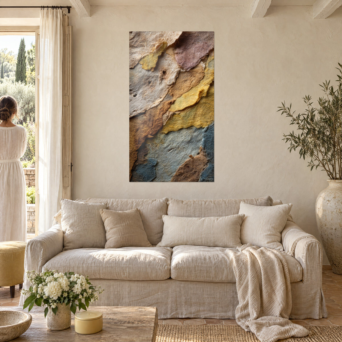 Quadro strati geologici in carta stropicciata, giallo ocra e blu ardesia, sopra un divano in un soggiorno luminoso