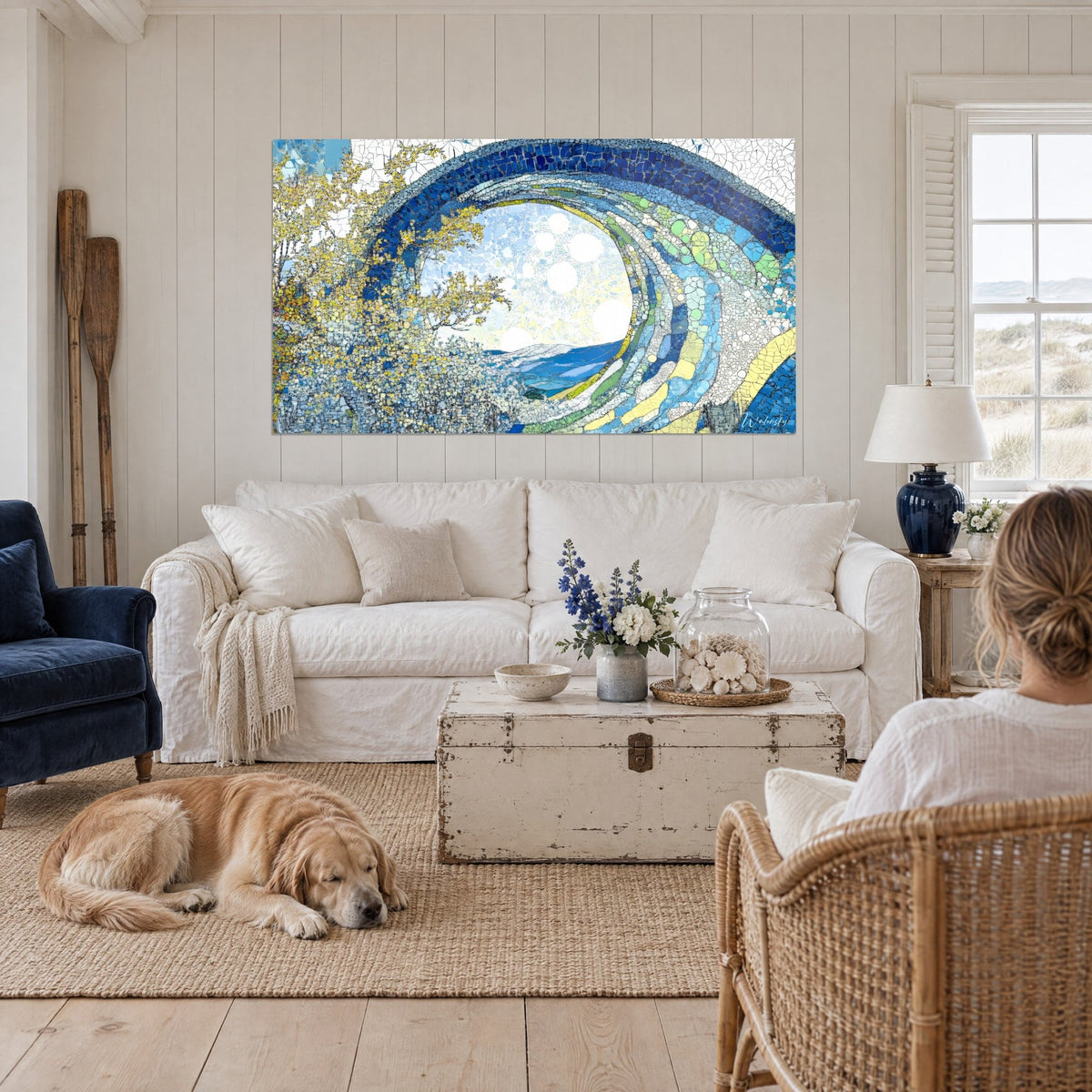 Wall art of a wave in cobalt blue and mimosa yellow mosaic tubes, with a lying retriever, above a sofa in a bright living room