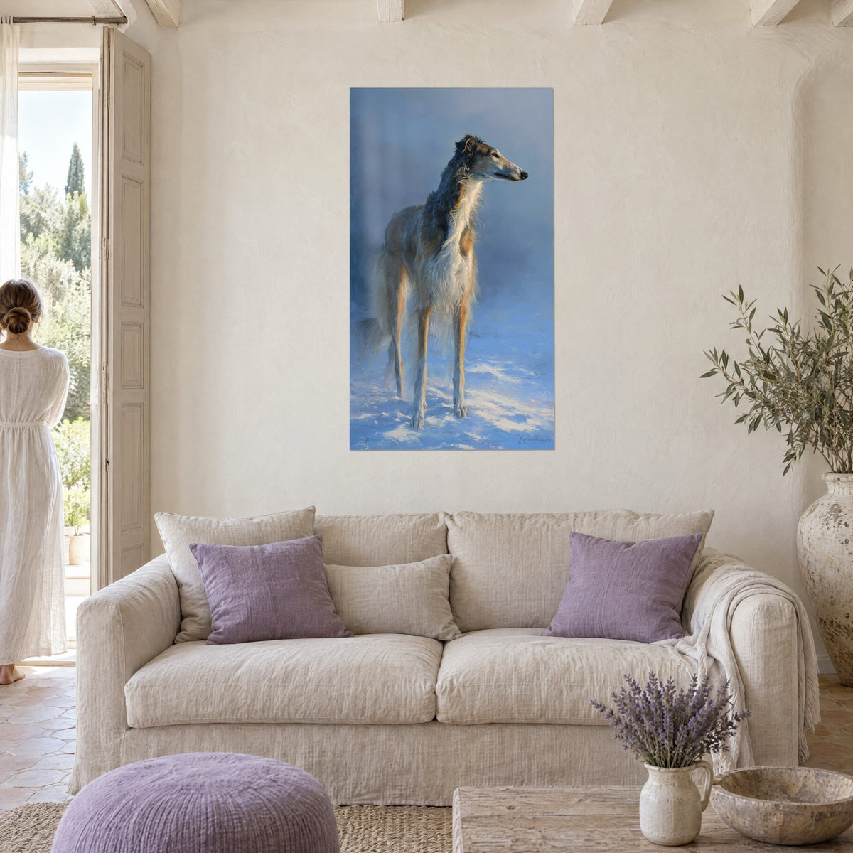 Wall art of a slender borzoi with cream and fawn coat in blue mist, a woman seen from behind, above a sofa in a bright living room