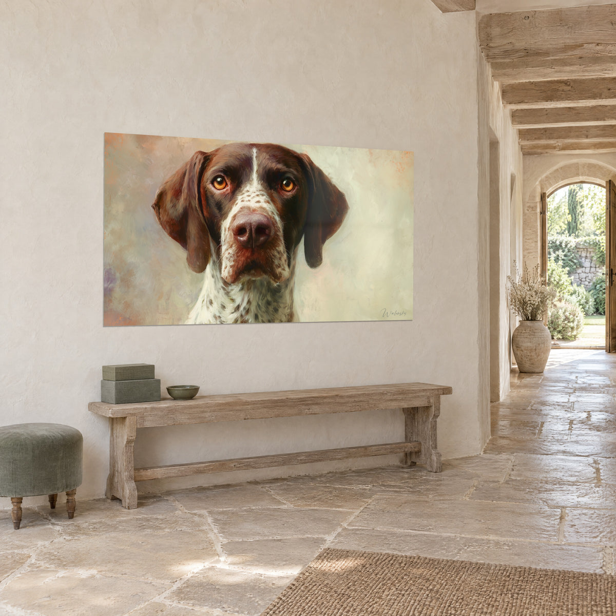 Cuadro retrato de perro de pelaje chocolate y crema, mirada dorada intensa, pared de piedra y baldosas claras de una casa de campo