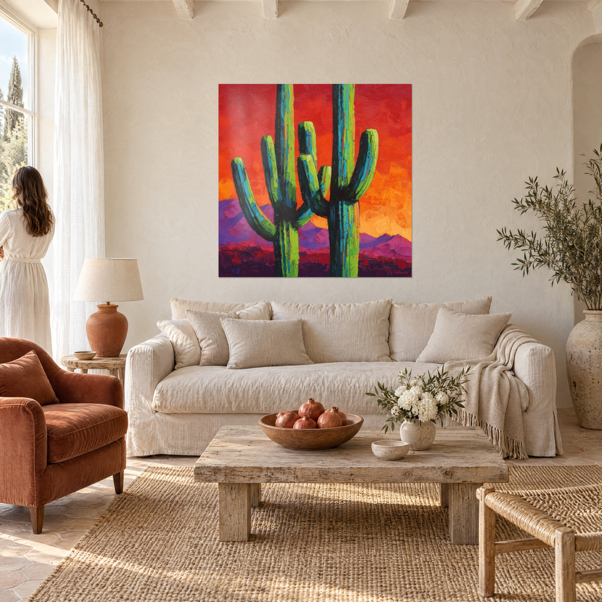 Tableau cactus saguaro vert citron sur ciel rouge incandescent, deux troncs sombres, au-dessus d'un canapé dans un salon lumineux