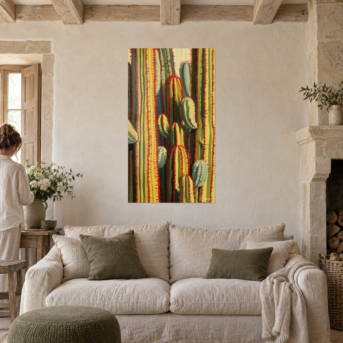Wall art of stylized cacti with red spines and olive green and mustard yellow stripes, two people seen from behind, above a sofa in a bright living room