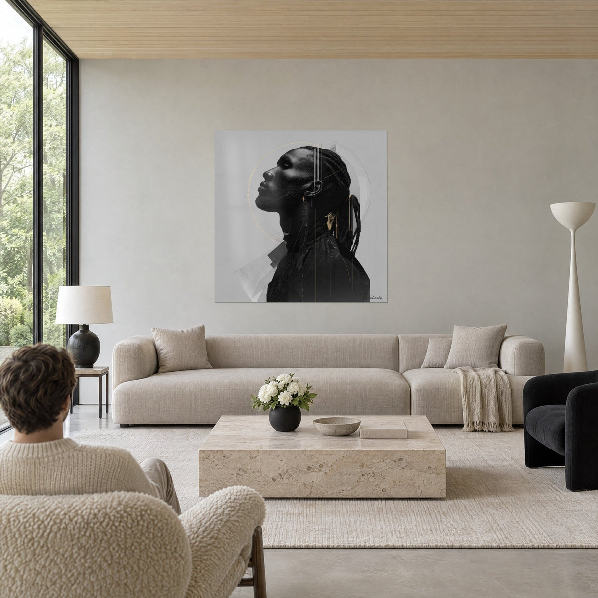 Wall art profile portrait of a Black man, braids and gold ring on pearl grey background, above a sofa in a bright living room