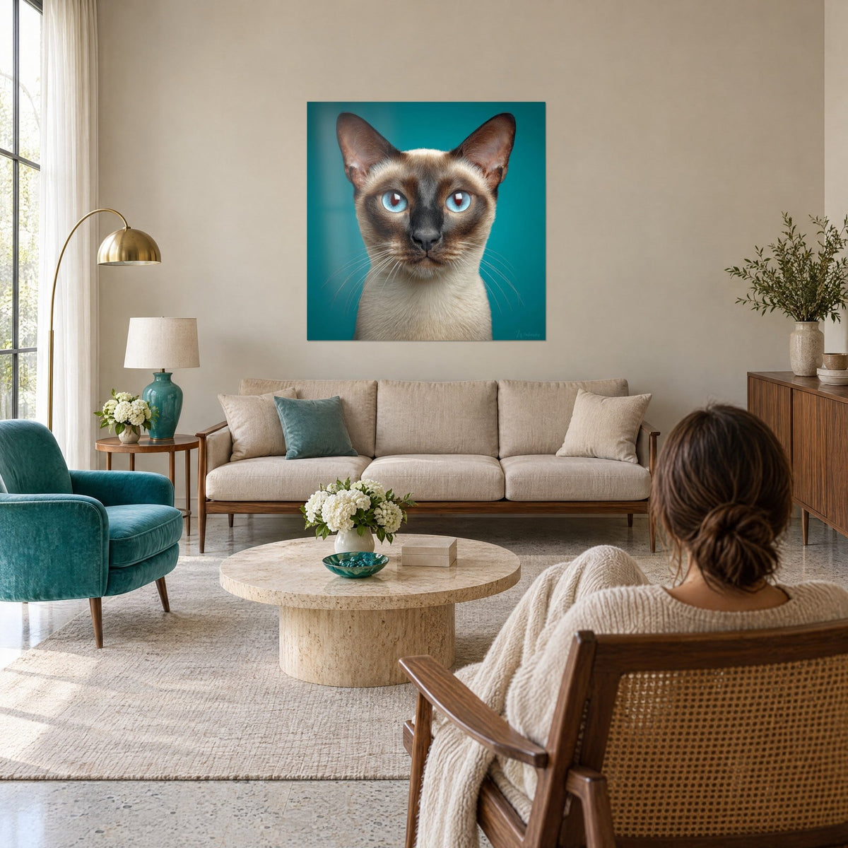 Gemälde Tonkinesische Katze mit blauen Augen, Schnauze kohlschwarz, türkisfarbener Hintergrund, über einem Sofa in einem hellen Wohnzimmer