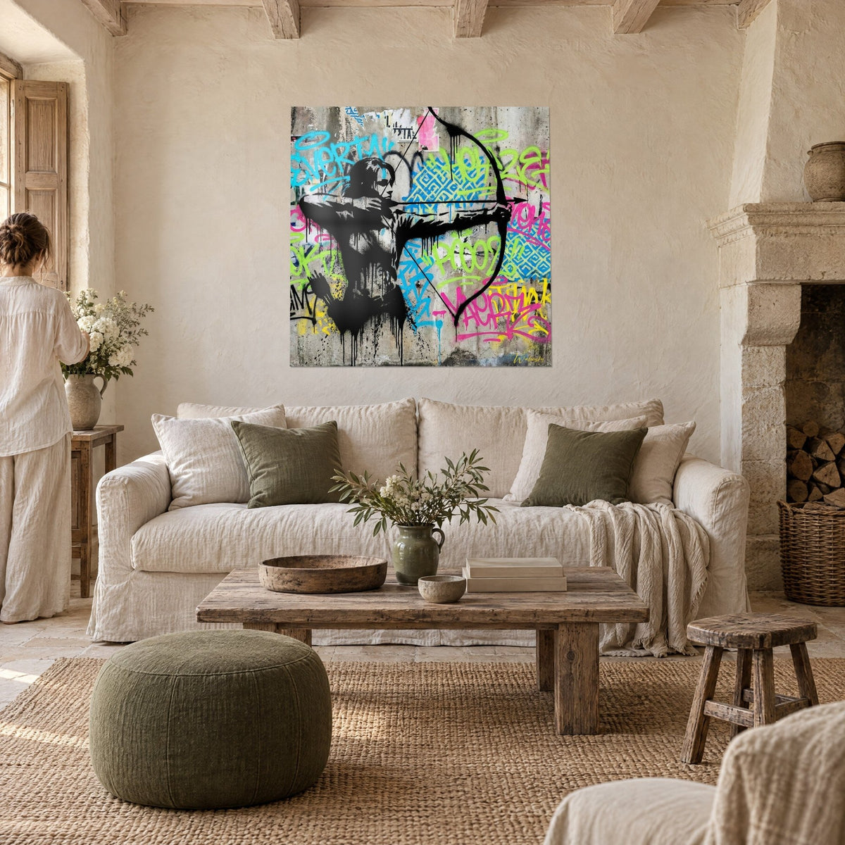 Tableau archer de graffiti en noir pochoir bandant son arc, fond cyan et vert anis, au-dessus d'un canapé dans un salon lumineux