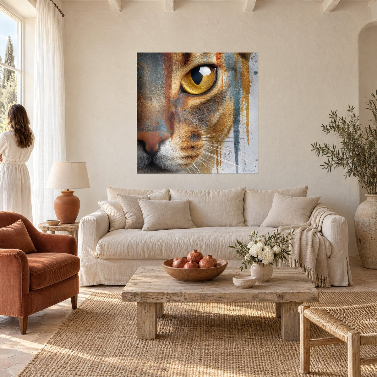 Cuadro gato abisinio de ojos dorados, goterones óxido y gris azulado, encima de un sofá en un salón luminoso