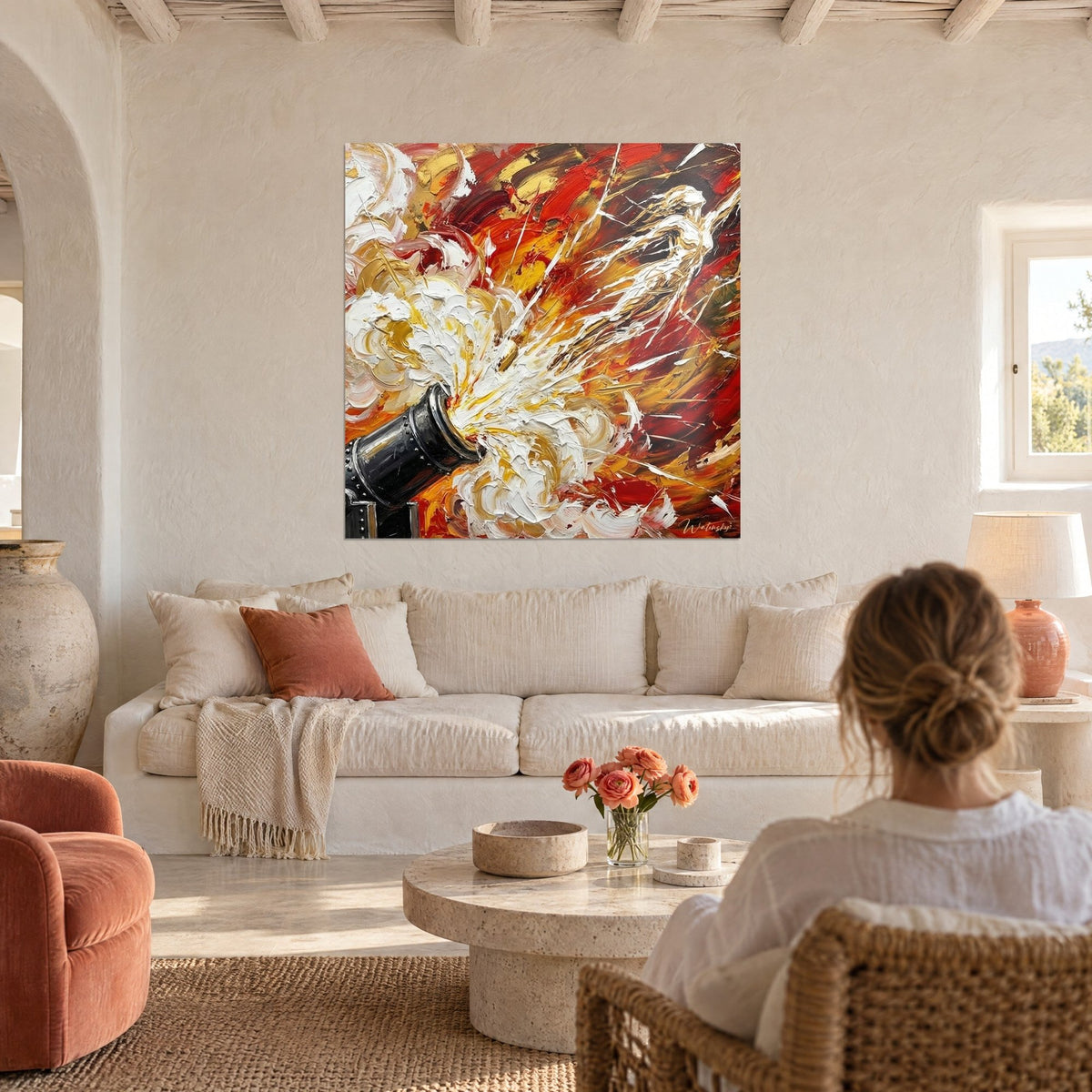 Wall art of a black cannon spraying a burst of white and gold paint on a vivid red background, above a sofa in a bright living room