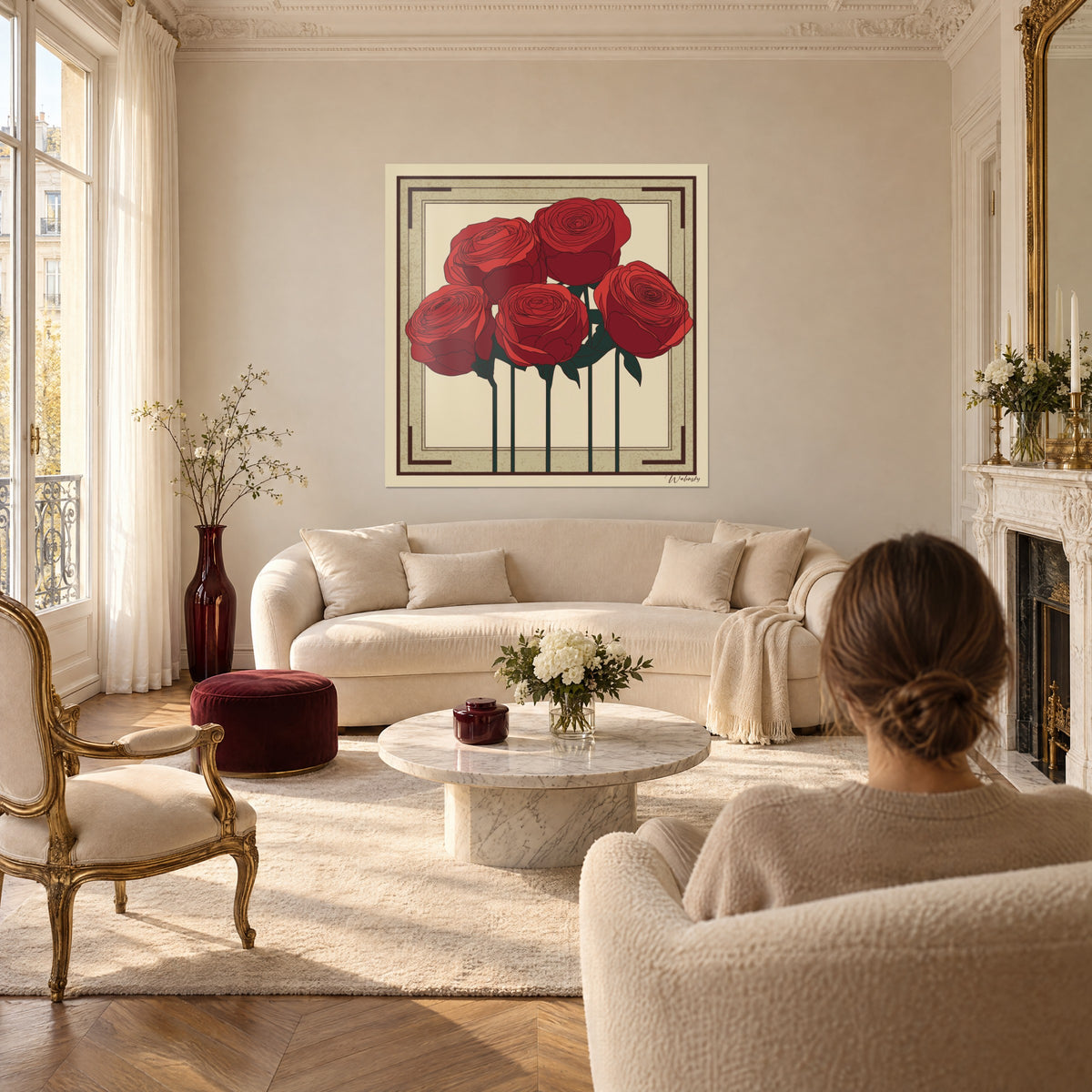 Tableau bouquet de cinq roses écarlates sur fond crème, cadre beige et brun, femme de dos au-dessus d'un canapé dans un salon lumineux