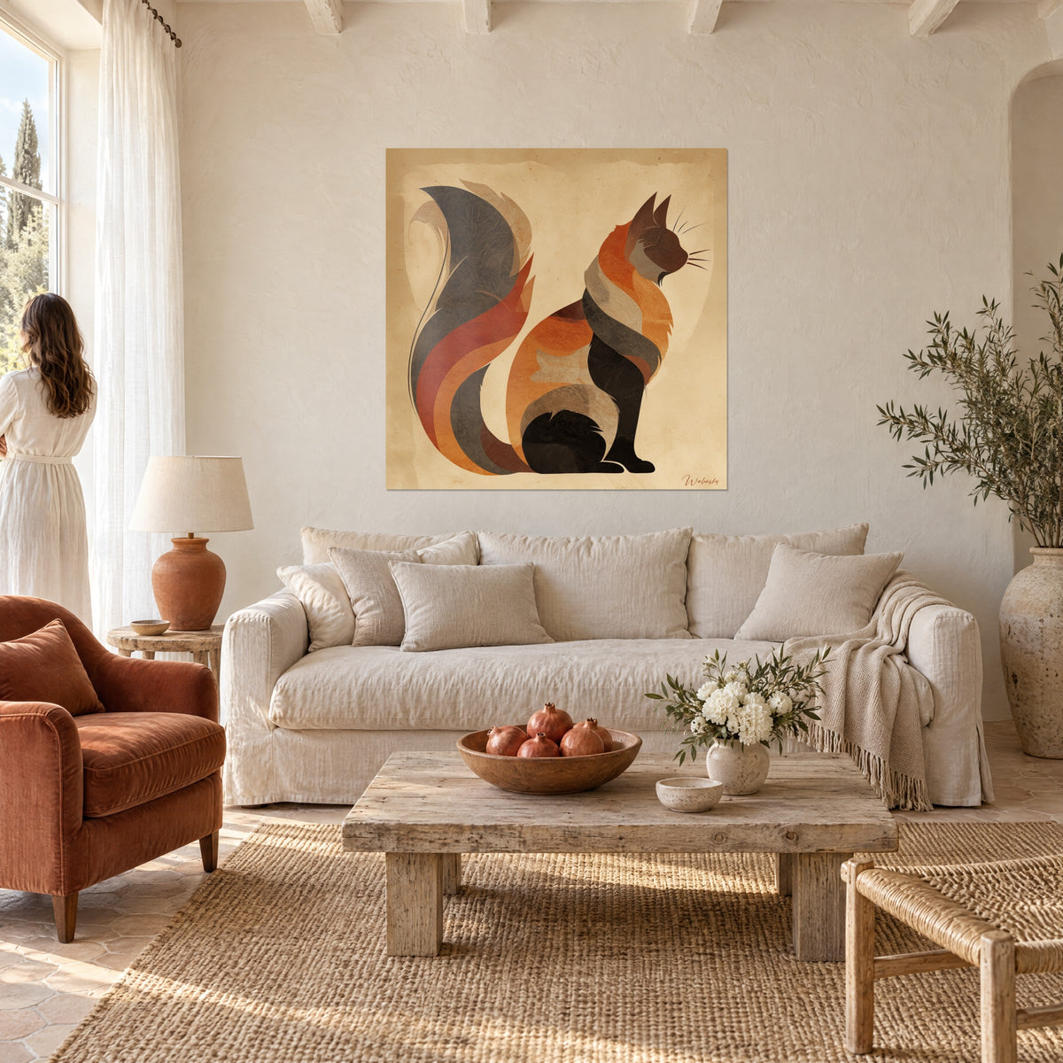 Tableau chat Somali assis aux courbes orange, gris et noir sur fond sable, une femme de dos, au-dessus d'un canapé dans un salon lumineux