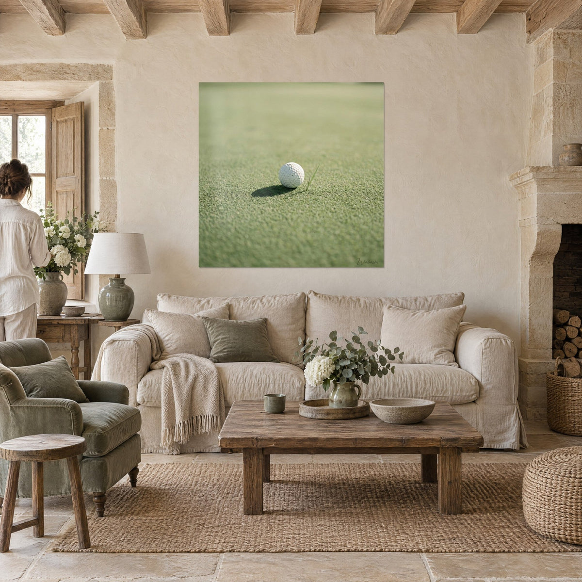 Gemälde Golfball mit Dellen auf zartgrünem Rasen, Schlagschatten, im Blick eines Paares von hinten, Leinensofa, helles Wohnzimmer