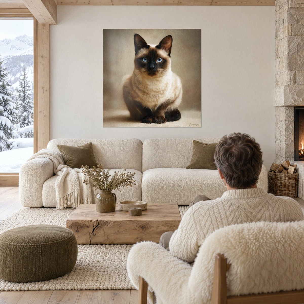 Gemälde Siamkatze sitzend mit blauen Augen, cremefarbenes Fell und braune Maske, gegenüber einem Mann von hinten über einem Sofa in einem hellen Wohnzimmer
