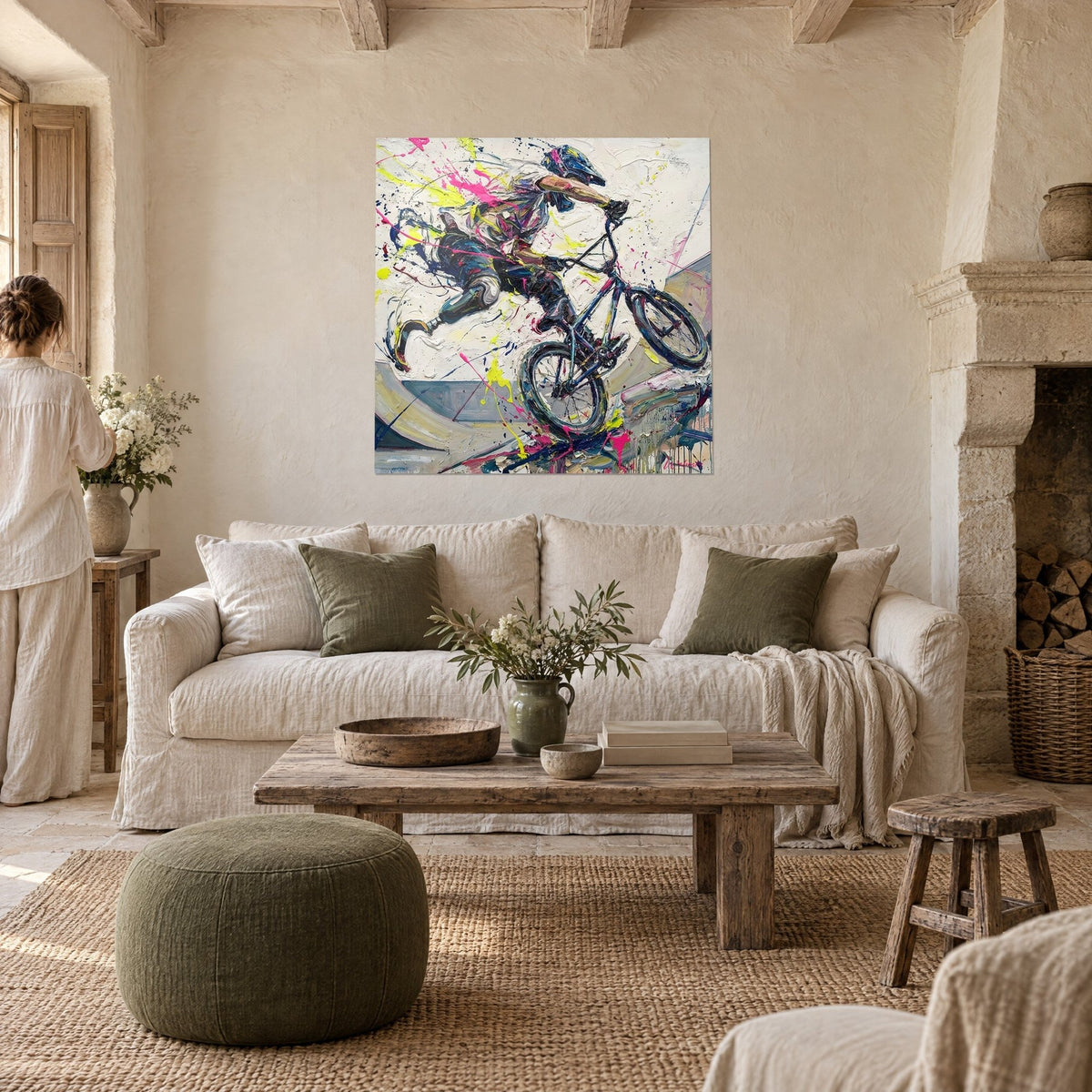Gemälde Radsportler BMX mit Beinprothese mitten im Sprung, Spritzer in Neonrosa und Zitronengelb auf cremefarbenem Grund, über einem Sofa in einem hellen Wohnzimmer
