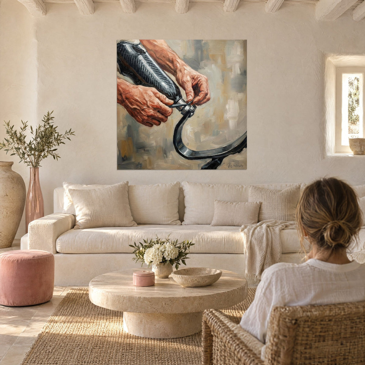 Tableau mains burinées vissant une prothèse en carbone, ocre et gris perle, au-dessus d'un canapé dans un salon lumineux