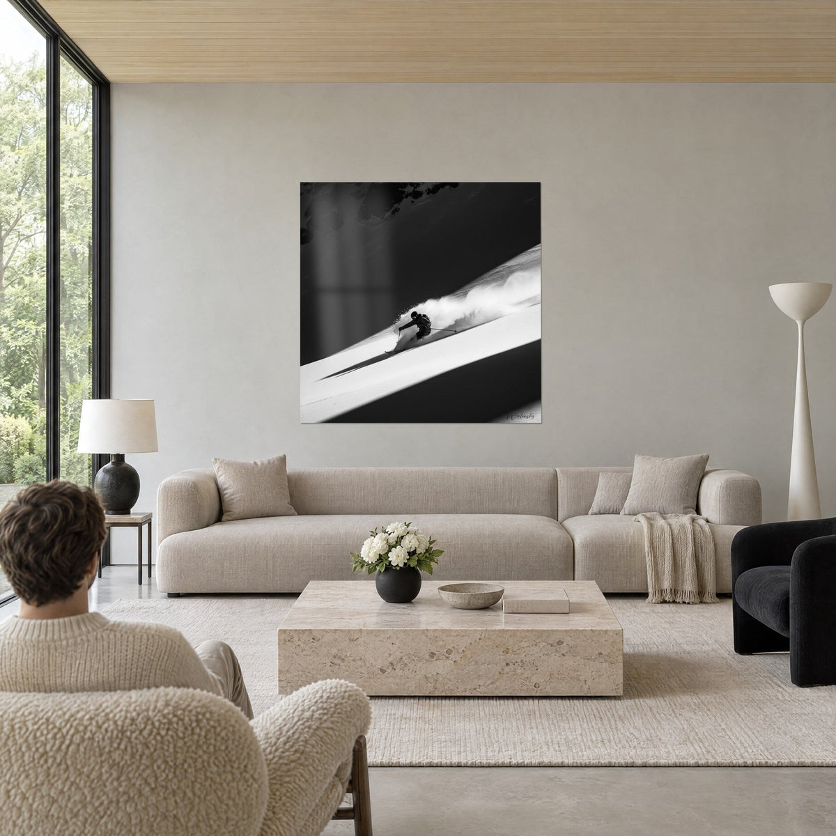 Tableau skieur lancé en poudreuse, panache de neige blanche sur pente en noir et blanc, au-dessus d'un canapé dans un salon lumineux