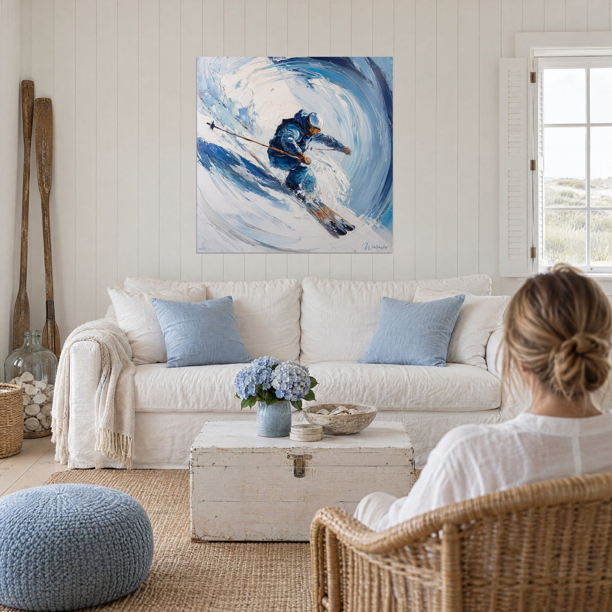 Tableau skieur penché dans un tourbillon de neige, veste bleu marine et masque orangé, au-dessus d'un canapé dans un salon lumineux