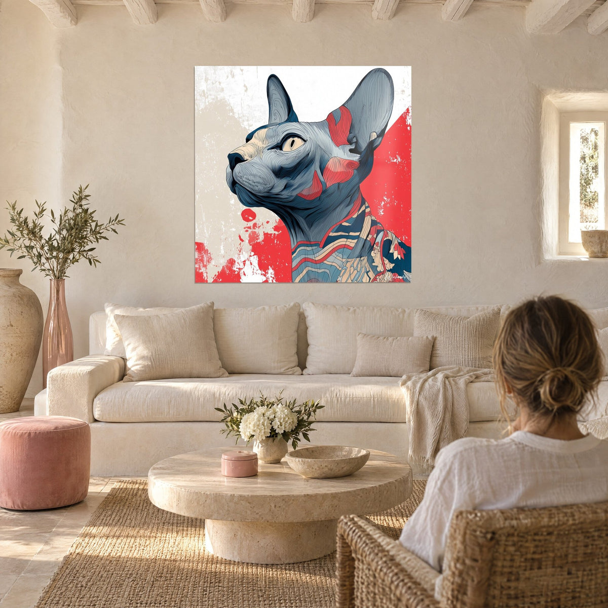 Wall art sphynx cat in upright profile, blue-grey skin and bold red blocks of colour, above a sofa in a bright living room