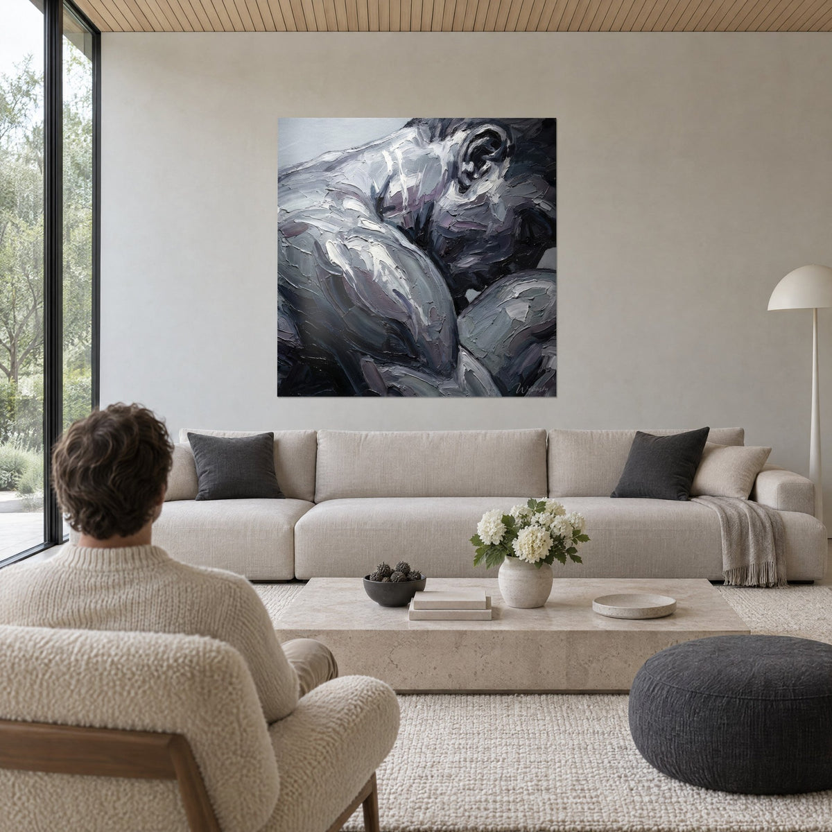 Tableau athlète musclé en empâtements gris argent et mauve, épaule massive, au-dessus d'un canapé dans un salon lumineux