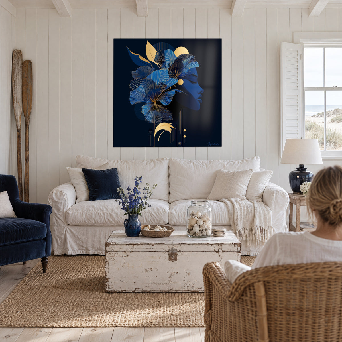Gemälde Profil einer Frau mit geschlossenen Augenlidern, königsblaue und goldene Ginkgoblätter auf nachtschwarzem Grund, über einem Sofa in einem hellen Wohnzimmer
