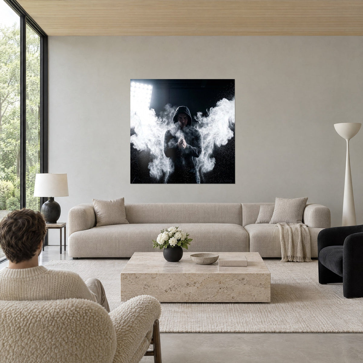Wall art of a hooded athlete clapping his hands in a white chalk cloud on a black background, above a sofa in a bright living room