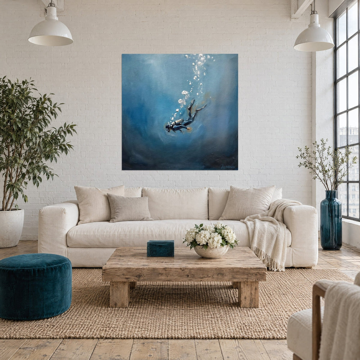 Wall art of a freediver descending into ultramarine blue, silver bubbles, black wetsuit, above a sofa in a bright living room