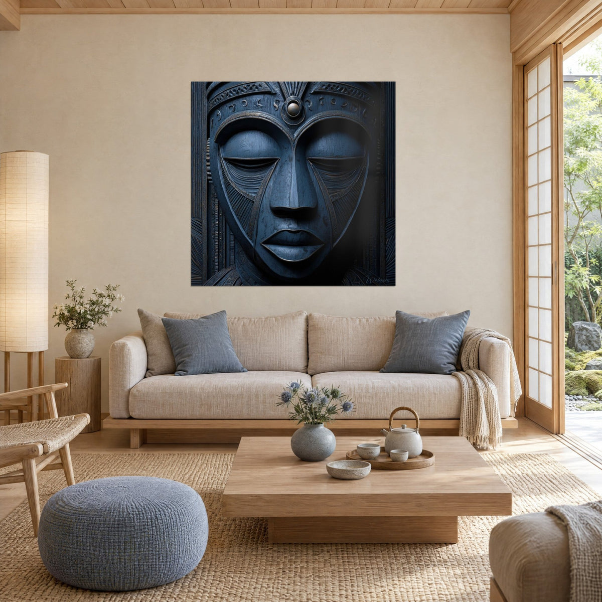 Quadro volto scolpito blu notte con palpebre chiuse e bordature ramate, sopra un divano in un soggiorno luminoso