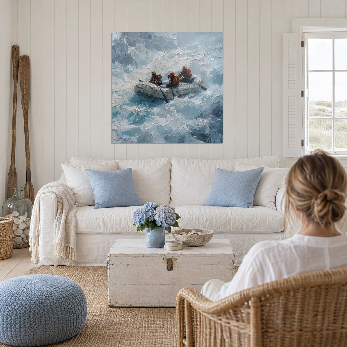 Gemälde Schlauchboot im Wildwasser, umgeben von weißer und blauer Gischt, drei Rafter mit orangefarbenen Helmen, über einem Sofa in einem hellen Wohnzimmer
