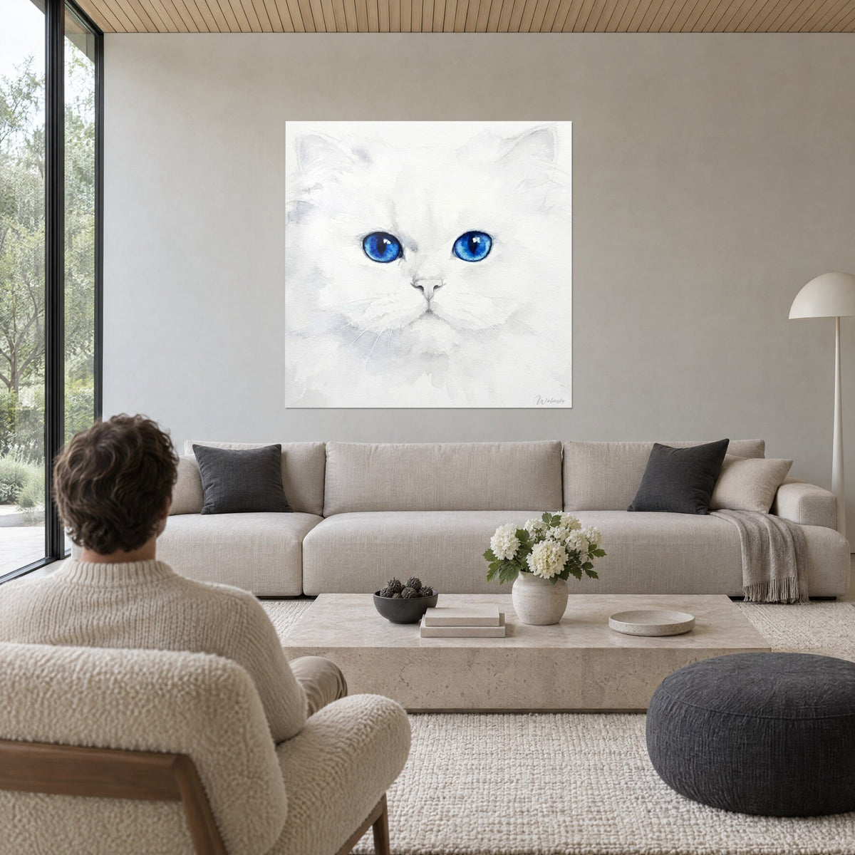 Cuadro gato persa blanco de ojos azules intensos, pelaje esponjoso gris perla, hombre de espaldas, sobre un sofá en un salón luminoso