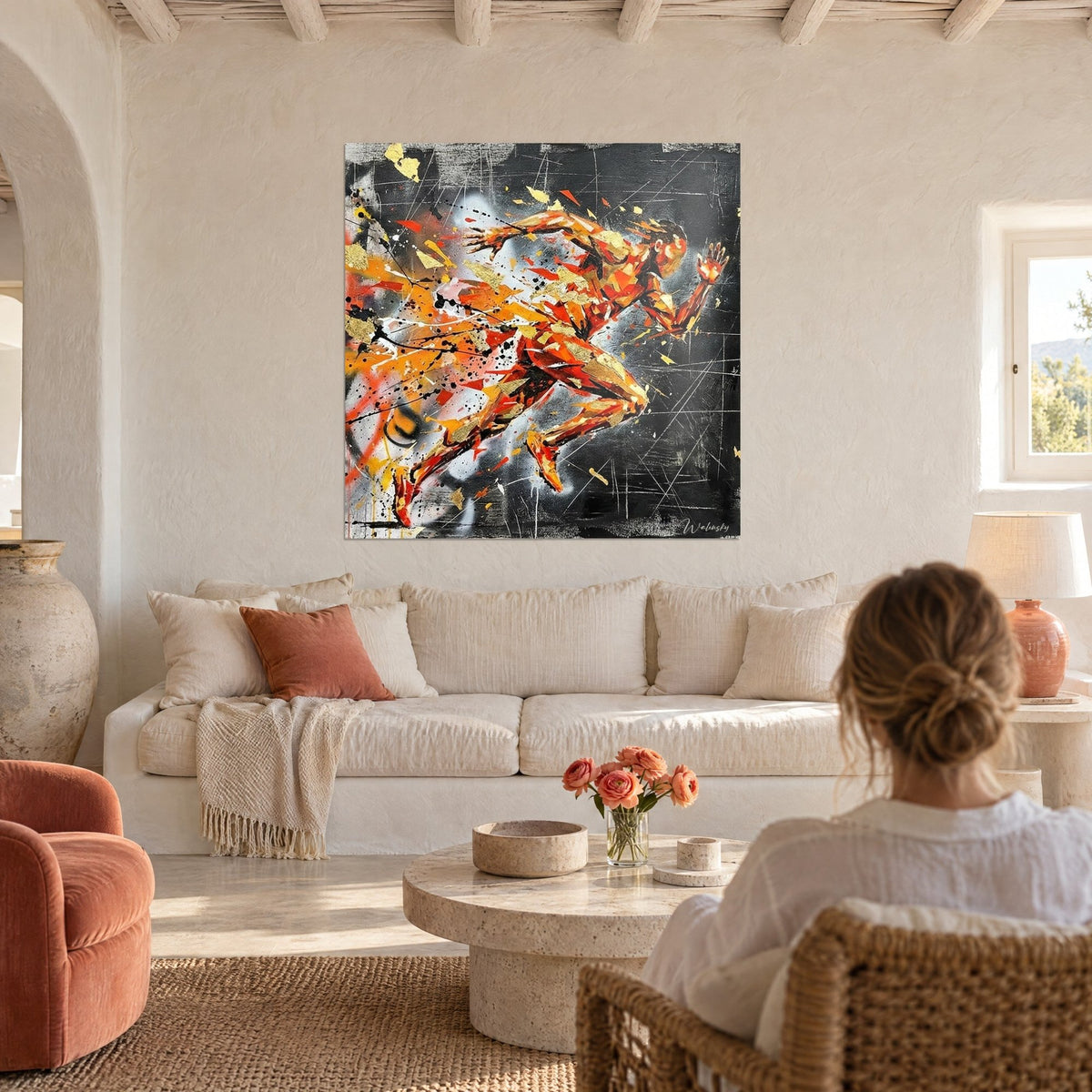 Wall art sprinter in orange and red shards on slate black background, golden splashes, above a sofa in a bright living room