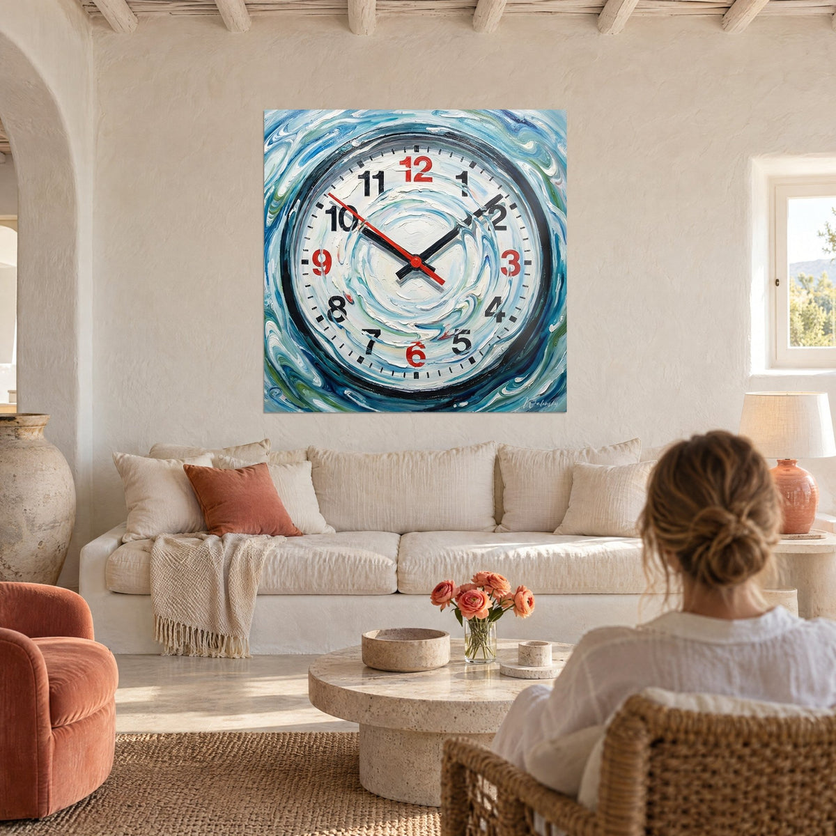 Gemälde Wanduhr mit rot-schwarzen Ziffern, eingebettet in einen blau-weißen Wirbel, über einem Sofa in einem hellen Wohnzimmer