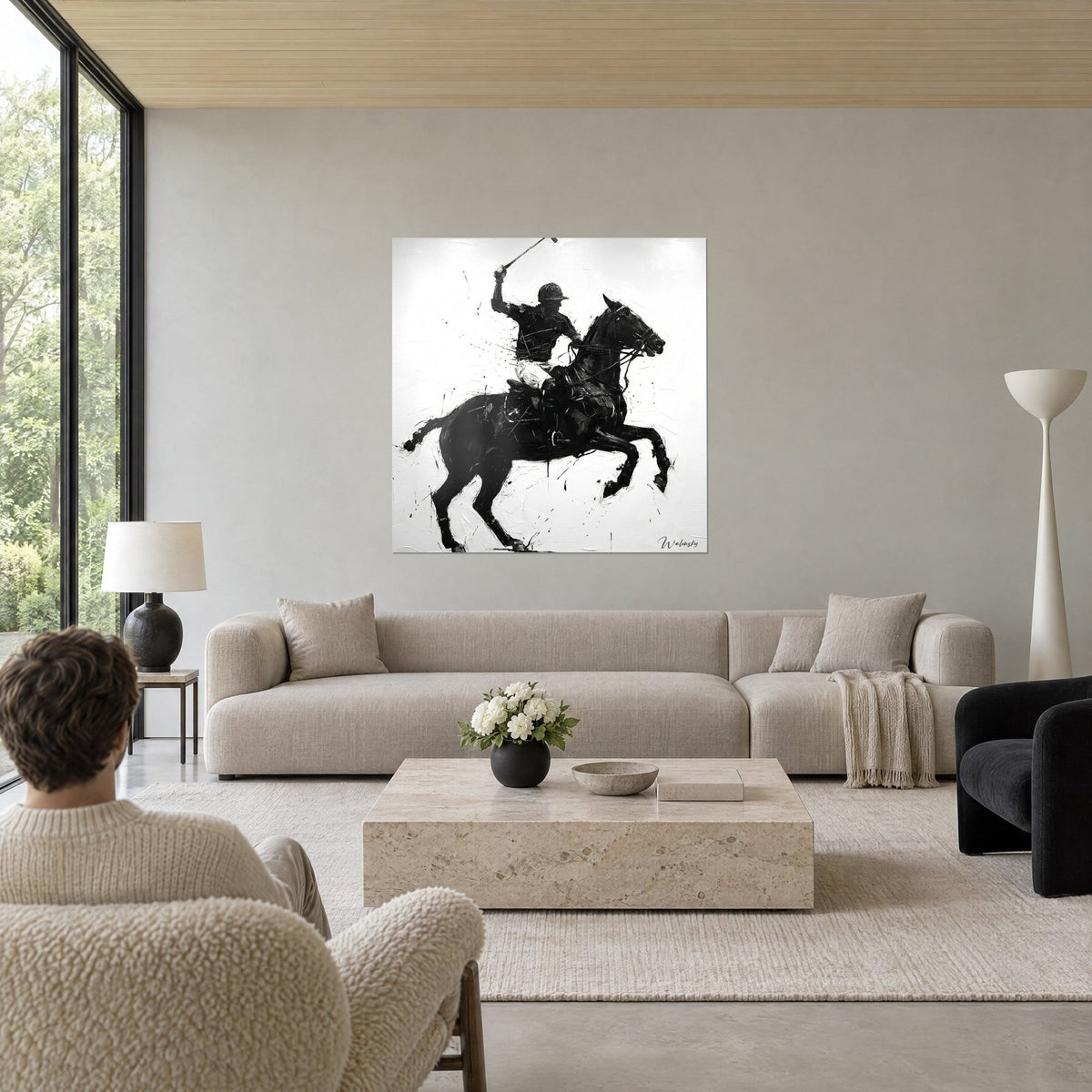 Wall art of a polo rider raising his mallet, black horse rearing up on a white background, above a sofa in a bright living room