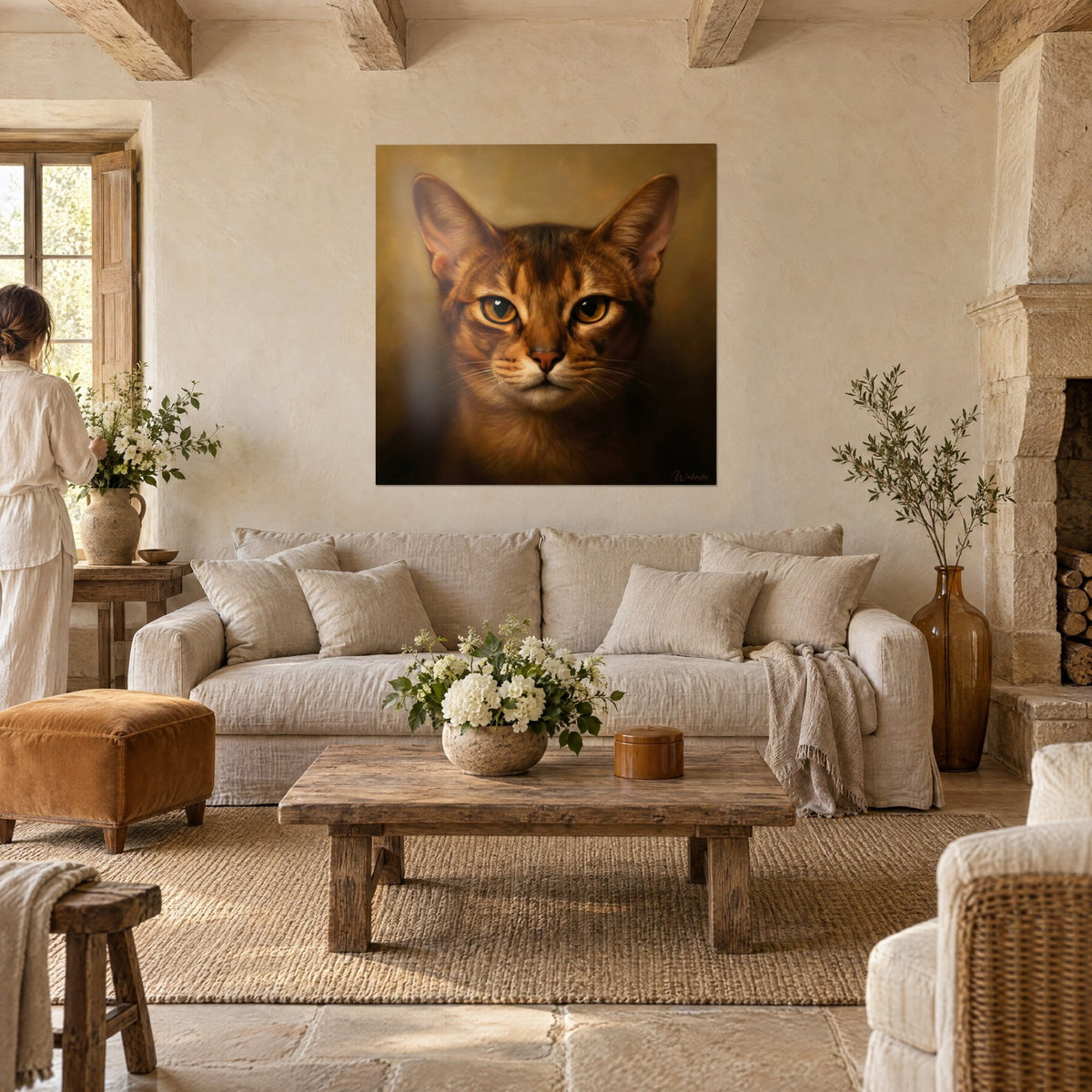 Tableau chat abyssin au pelage roux rayé et yeux ambrés, face à deux personnes de dos, au-dessus d'un canapé dans un salon lumineux