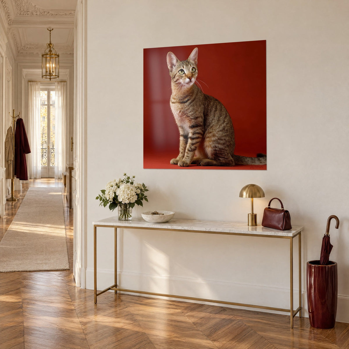 Gemälde schlanke Katze mit grünen Augen und dunklen Streifen auf karminrotem Hintergrund, über einer goldenen Konsole im Eingangsbereich