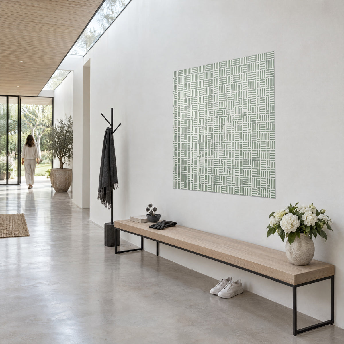 Cuadro mosaico de trazos verde agua y marfil que dibuja un corredor fantasma, colgado en una pared blanca de pasillo iluminado